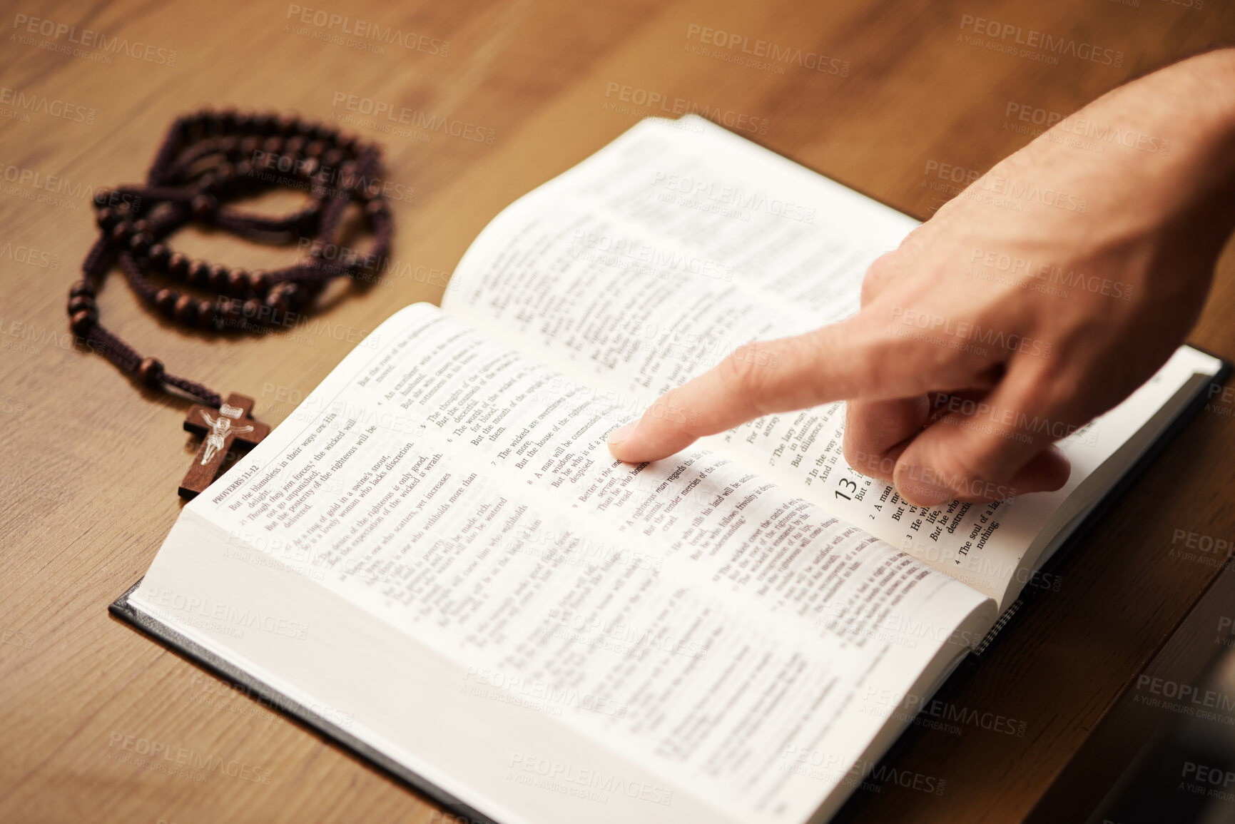 Buy stock photo Hands, person and reading bible with rosary cross for praying, spiritual faith and holy worship of God. Closeup of christian studying religion, gospel prayer books and learning praise to Jesus Christ