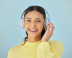 Portrait of happy woman, headphones and mockup in studio listening to podcast, mobile app and streaming radio site. Smile, music media subscription and sound, face of girl on blue background space.