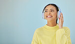 Happy woman, headphones and banner mockup in studio listening to podcast, app and streaming radio site. Smile, music media subscription and sound, face of girl with audio on blue background space.