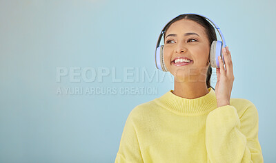 Buy stock photo Happy woman, headphones and banner mockup in studio listening to podcast, app and streaming radio site. Smile, music media subscription and sound, face of girl with audio on blue background space.