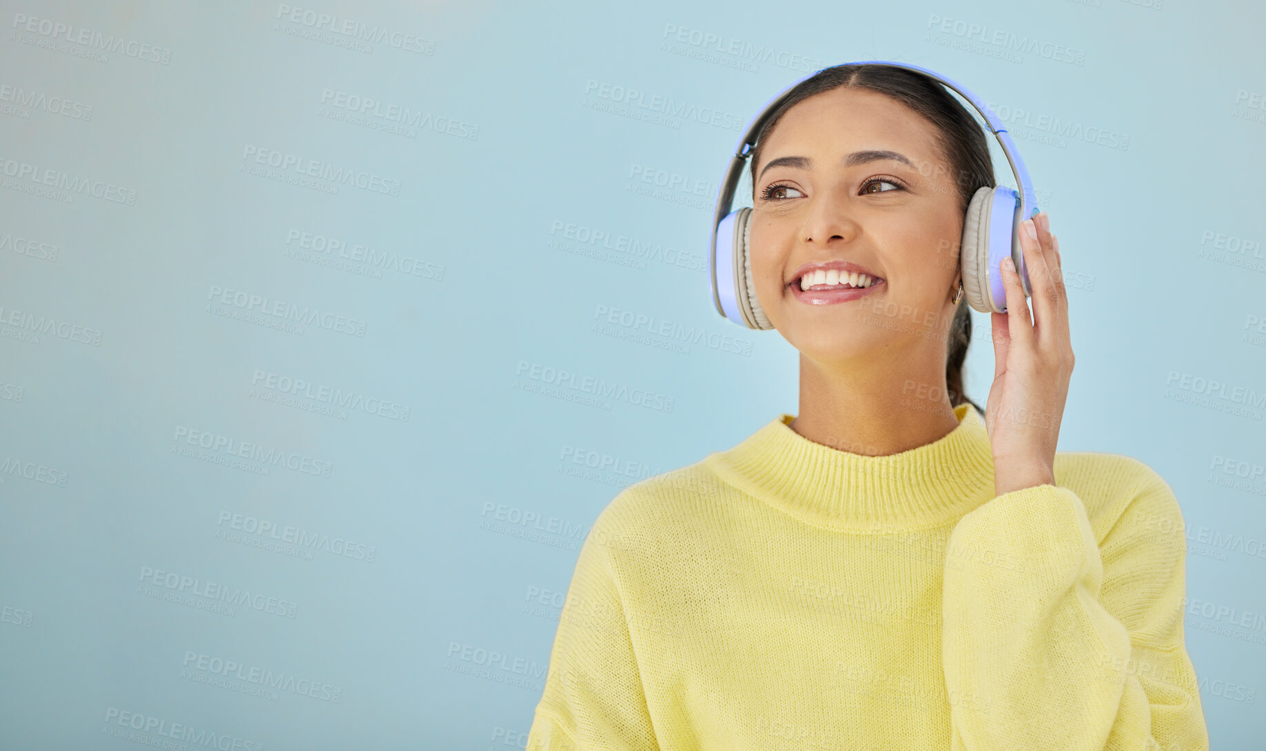 Buy stock photo Happy woman, headphones and banner mockup in studio listening to podcast, app and streaming radio site. Smile, music media subscription and sound, face of girl with audio on blue background space.