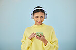 Woman with phone, headphones and mockup in studio for social media post, mobile app and streaming radio site. Smile, music media subscription and happy girl with cellphone on blue background space.