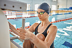 Swimming, sports and woman start in pool for exercise, training and workout for competition in gym. Fitness, podium and female swimmer holding block for water sport race, challenge and performance