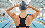 Woman, back and ready by swimming pool for fitness competition, training and gym exercise. Athlete, swimmer and person with water sports gear, cap and swimsuit in workout challenge, race and practice