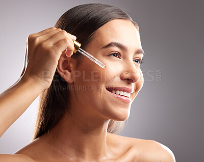 Buy stock photo Beauty, face and happy woman with serum dropper for skincare hydration, facial cosmetics glow or anti aging wellness. Collagen oil treatment, dermatology and studio person on gradient grey background