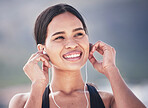 Fitness, smile and woman with music earphones outdoor for running, training and sports routine on blurred background. Exercise, podcast and happy female runner with radio, track and audio motivation