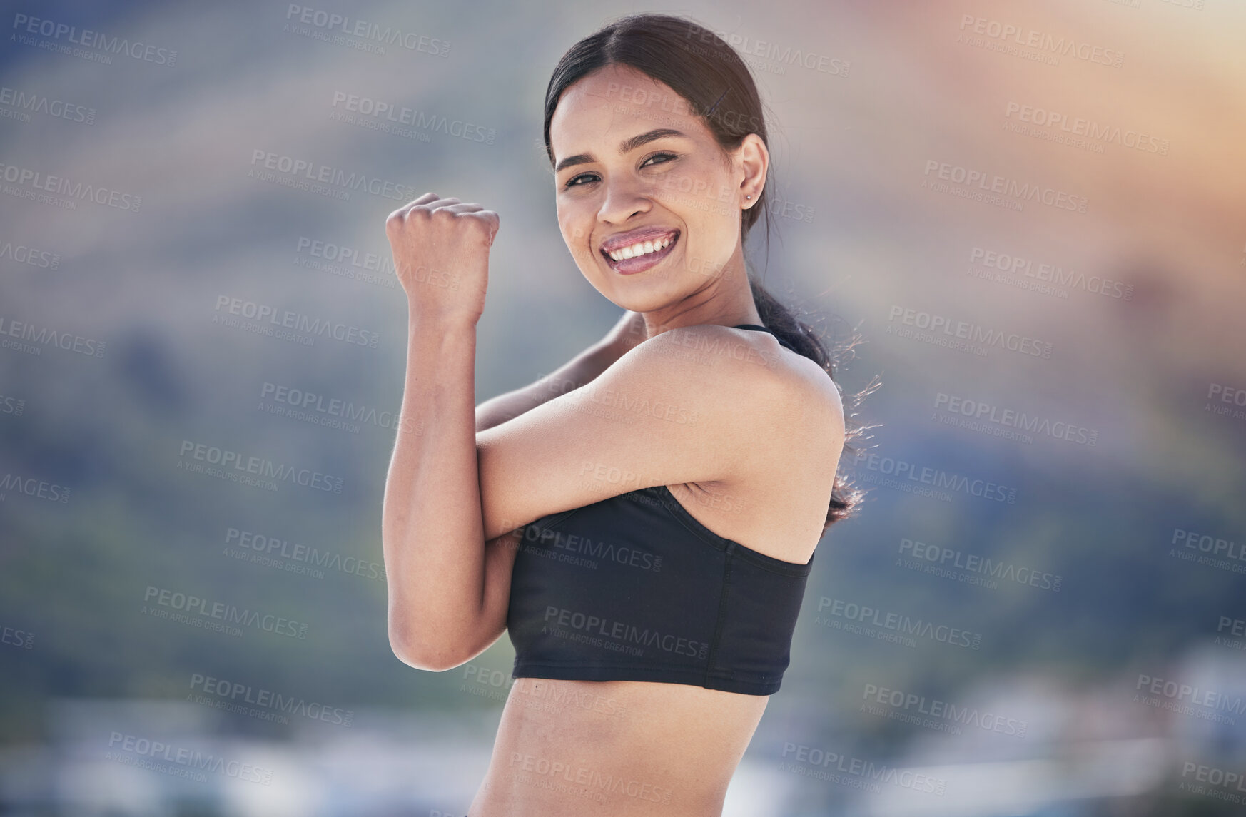 Buy stock photo Fitness, portrait and happy woman stretching arm outdoor for running, training or morning cardio routine on blurred background. Face, smile and female runner with shoulder stretch exercise or warm up