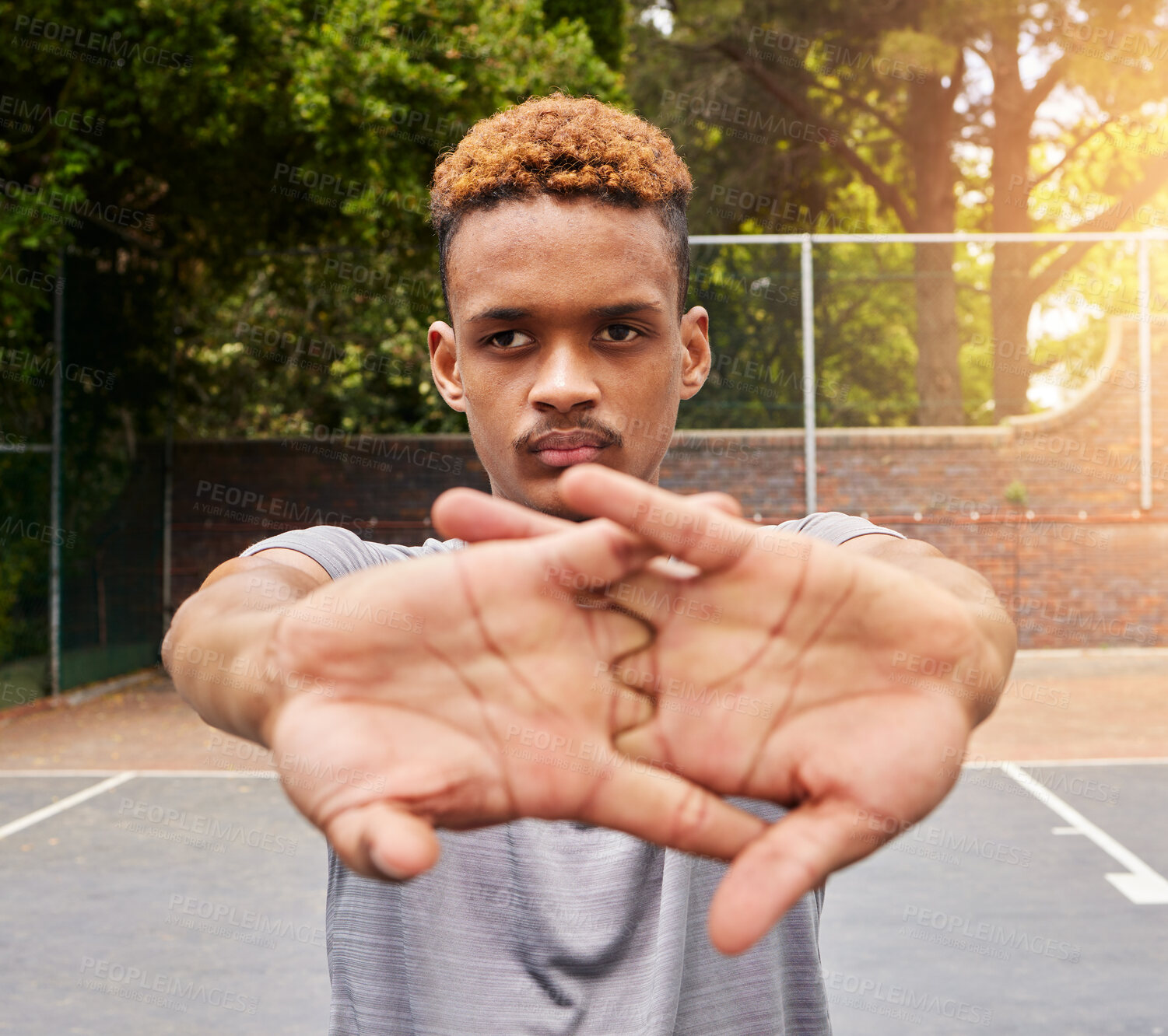 Buy stock photo Sports, basketball and man stretching on court for competition, training or fitness games. Face of serious male athlete, player and warm up arms for workout, thinking of performance action or contest