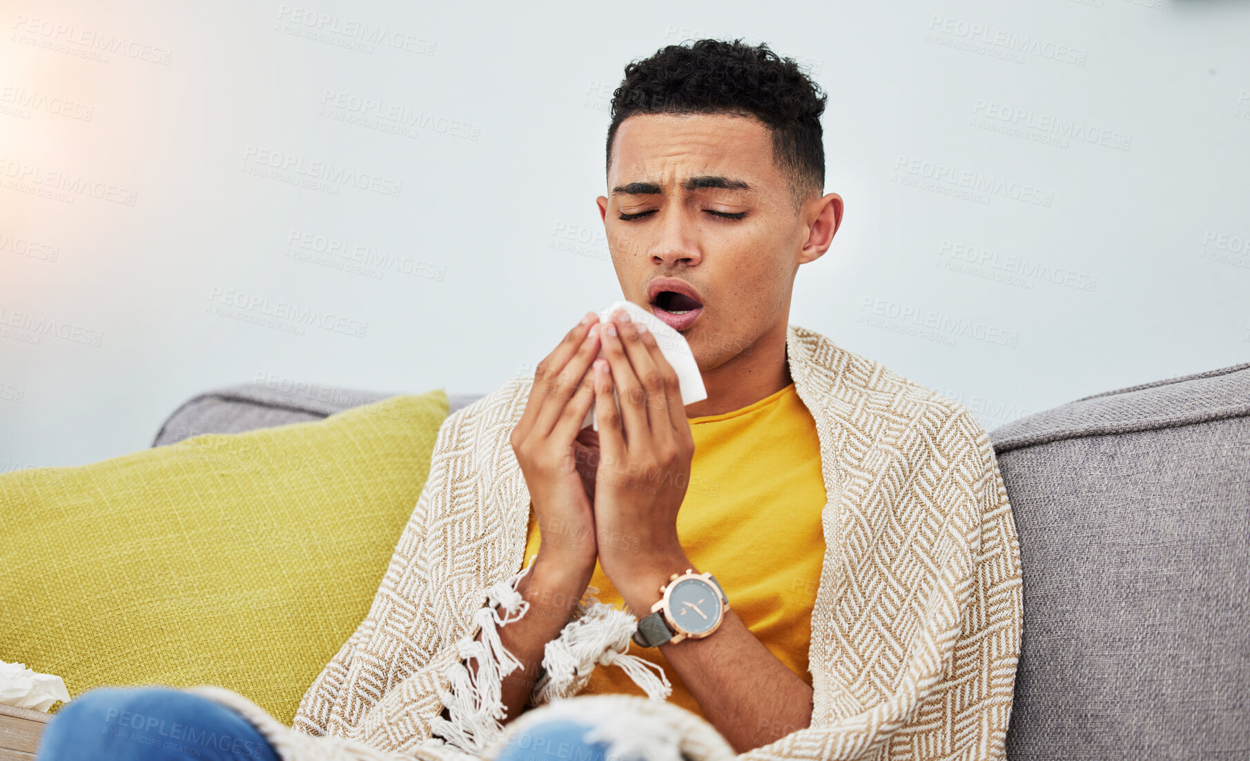 Buy stock photo Sick, couch and man with flu sneeze due to cold, sinus and fever in a home living room with a blanket on a sofa. Healthcare, sad and young person with difficult symptoms or medical problem in house