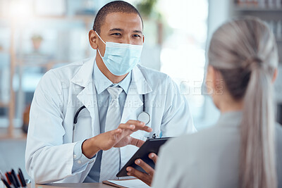 Tablet, face mask and doctor consulting a patient in a health conversation or communication during medical consultation. Medicine, healthcare and professional talking to person for results in clinic