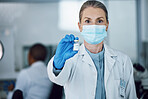 Portrait of woman doctor with face mask and vaccine bottle in hand at hospital laboratory for covid research. Healthcare, medicine and medical professional with sample for corona vaccination in lab.