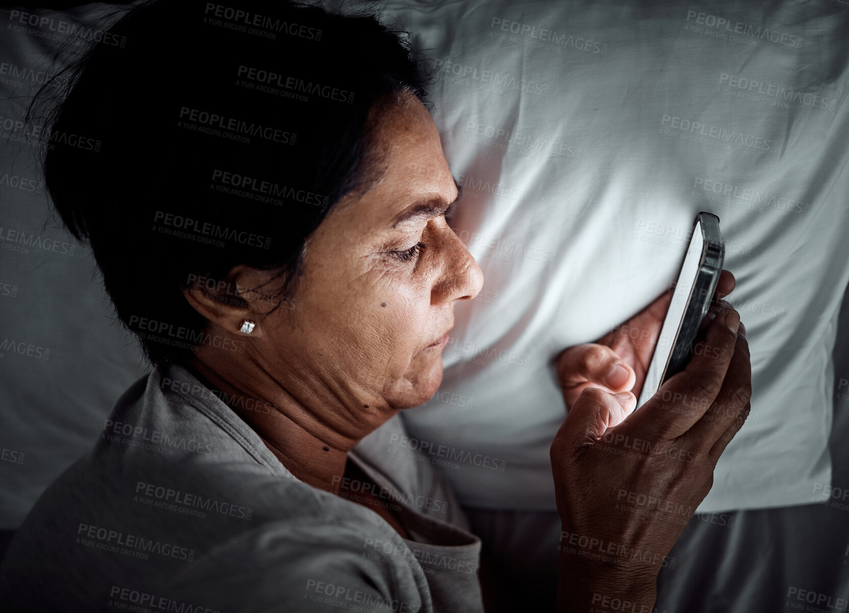 Buy stock photo Insomnia, night and smartphone with senior woman in bedroom for social media app, dark and addiction. Communication, contact and internet with female person in bed at home with stress and online chat