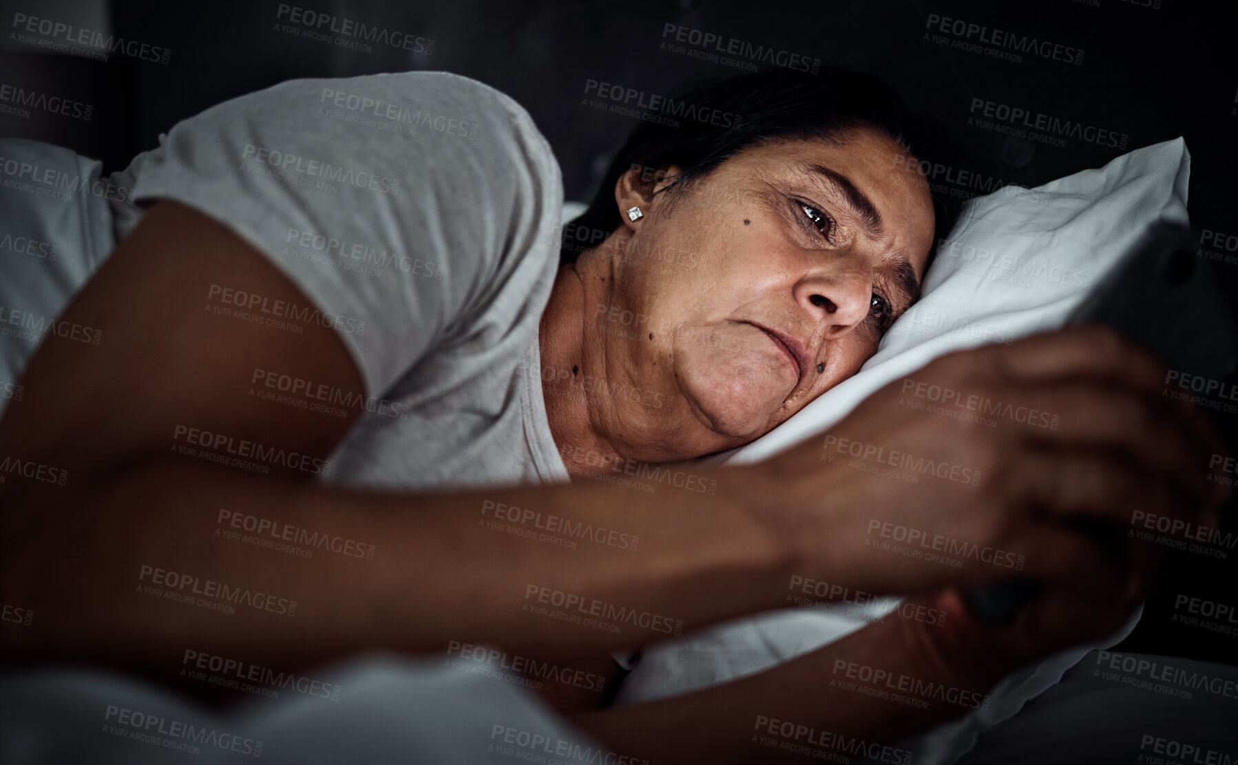 Buy stock photo Insomnia, night and phone with old woman in bed for social media, thinking and communication. Tired, fatigue and relax with senior person in bedroom at home for mobile app, streaming and contact