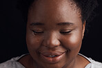 Happy, eyes closed and a black woman with a smile on a black background for peace or beauty. Calm, closeup and face of an African girl, person or model with pride isolated on a studio backdrop