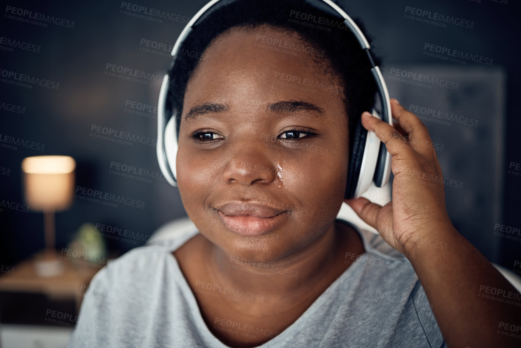 Buy stock photo Crying, sad and black woman with headphones for music, sound or audio. Tears, radio and plus size African person listening, hearing and streaming podcast with depression, crisis and problem in home