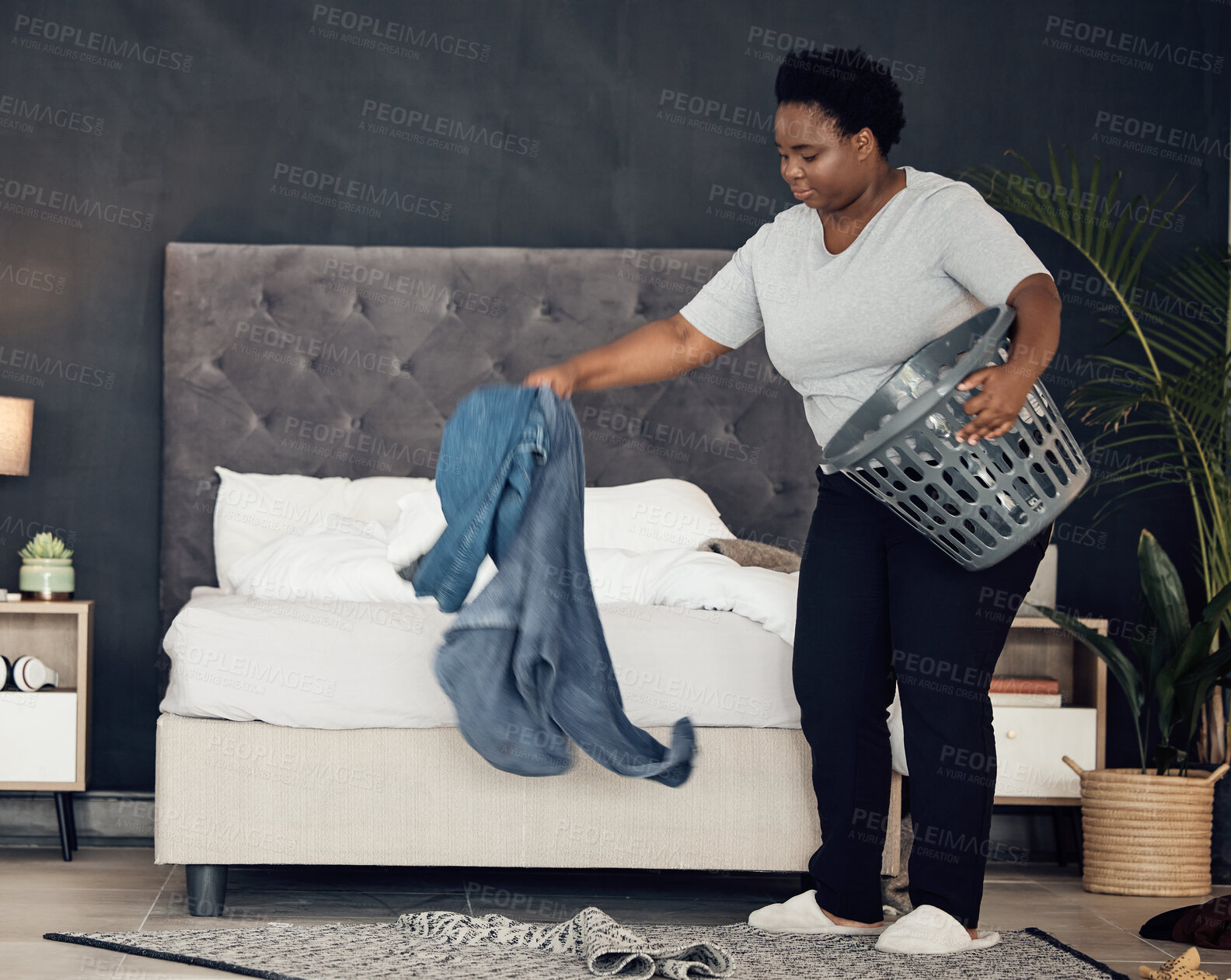 Buy stock photo Black woman, clothes with basket and cleaning bedroom, organize mess with hygiene and hospitality. Female person, cleaner and housekeeping, busy with laundry and maintenance with morning routine