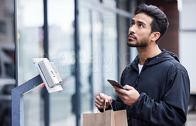 Buy stock photo Courier man, paper bag and city with phone, typing and delivery app with search in supply chain job. Young logistics worker, package and thinking with smartphone, product and ecommerce in metro cbd