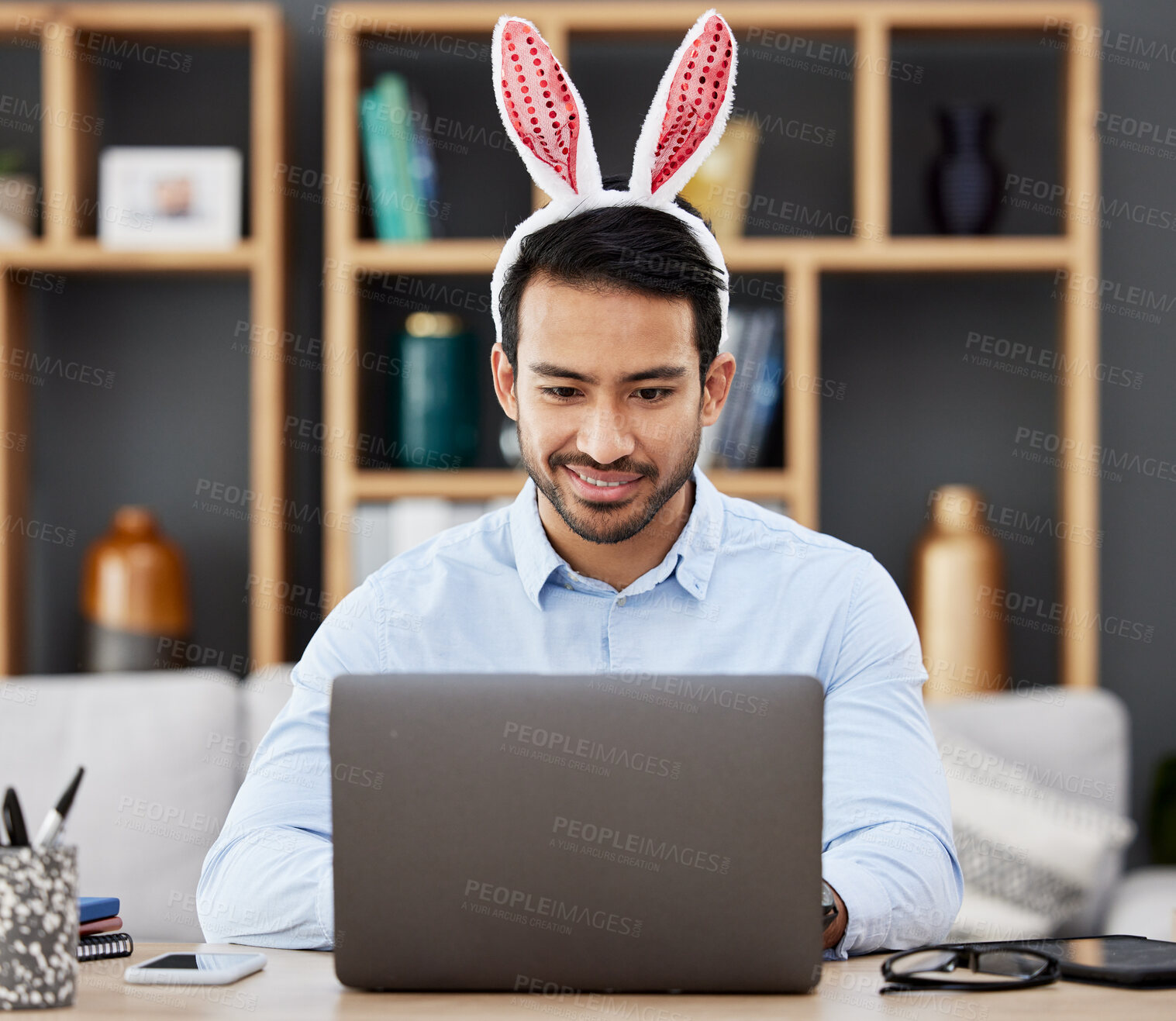 Buy stock photo Laptop, bunny ears and business man  in office with decoration for celebration, event and Easter party. Corporate, happy and Asian male person on computer at desk with rabbit headband for holiday