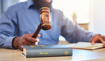 Hands, lawyer and gavel on books in office for attention, guide and justice in courtroom, law firm or truth. Closeup of hammer, legal knowledge and man for consulting attorney, judge and constitution