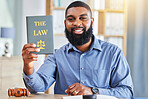 Happy, man and portrait with a book on the law, rules or research on legal constitution, regulation or policy from government. African businessman, lawyer or attorney with knowledge of justice