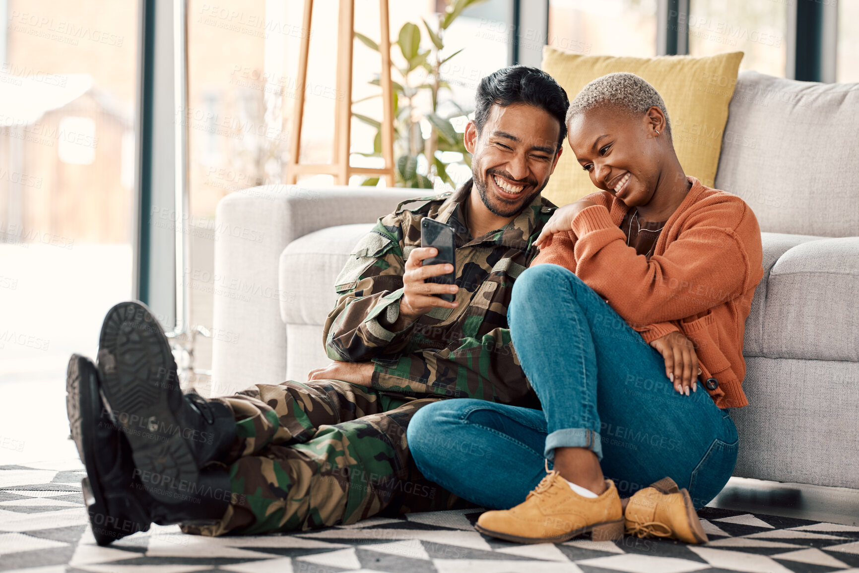 Buy stock photo Army man, interracial couple and return with phone video on a sofa at home with love and care. Lounge, young people and mobile scroll in a house sitting on ground relax with travel picture of soldier