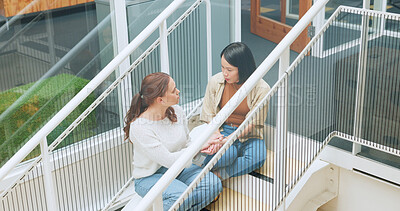 Friends, women sitting on stairs at apartment building and talking, sharing advice and support in life crisis. Trust, help and sad woman with friend on steps having a talk about problem outside home.