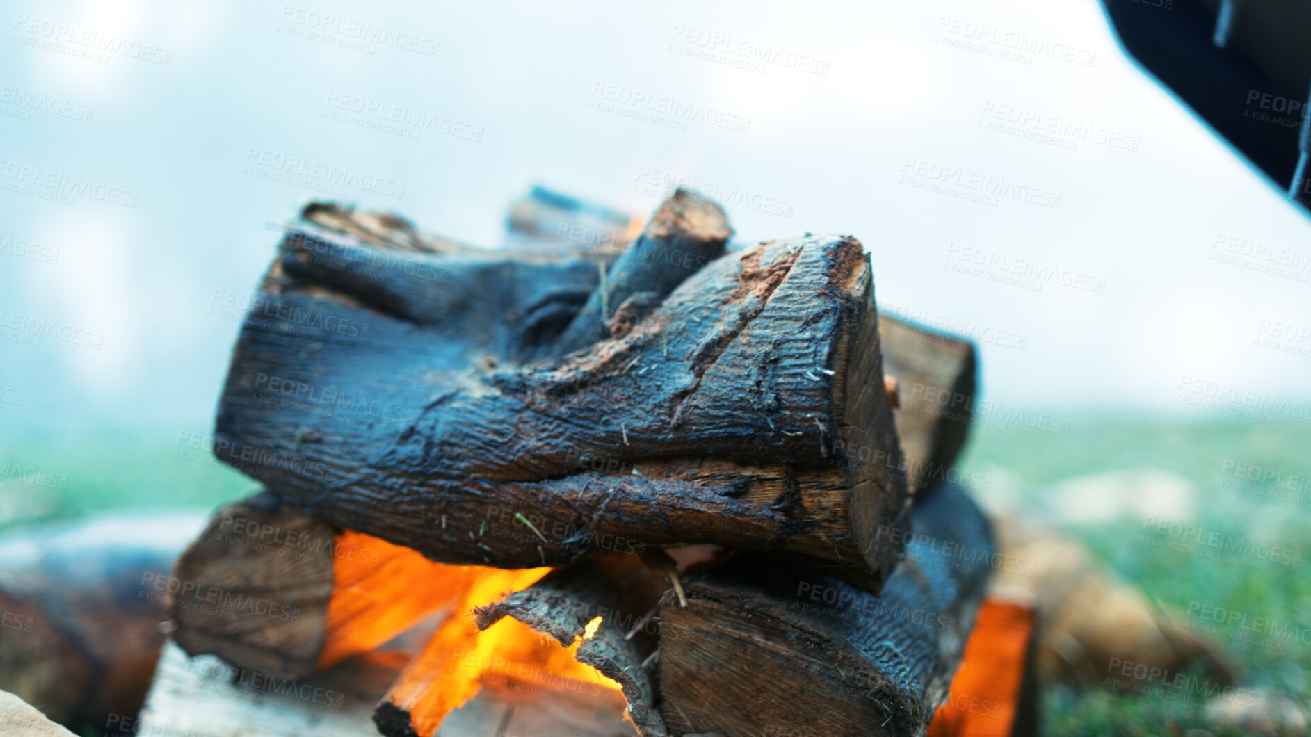 Buy stock photo Bonfire circle, camp and outdoor in nature with stone, rock and safe on ground, grass and a closeup. Fire, flames and burn wood for heat, cooking or relax on lawn, field and woods for holiday