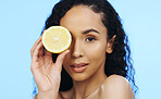 Lemon, face skincare and beauty of woman in studio, vegan wellness or blue background. Model, portrait and citrus fruits for facial cosmetics, vitamin c aesthetic or healthy natural detox dermatology