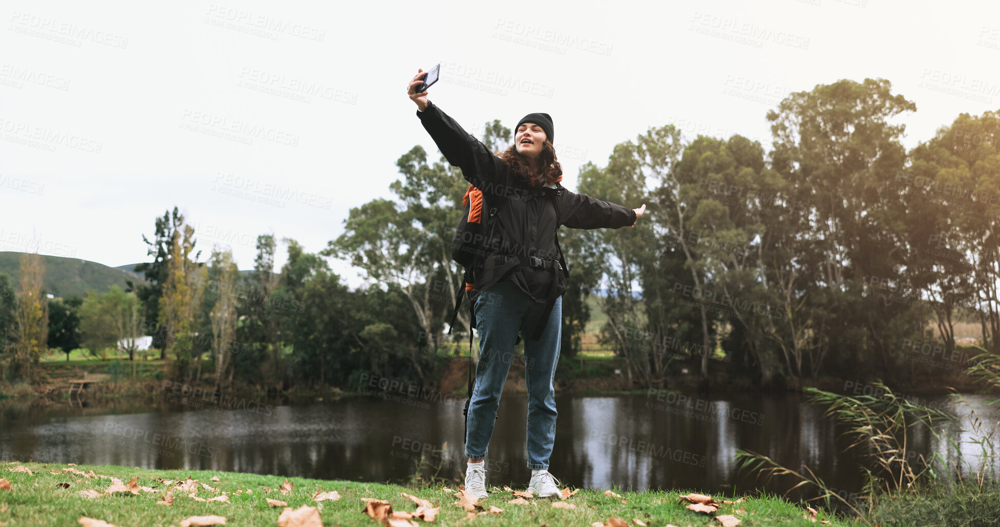 Buy stock photo Woman, happy video call and hiking adventure at lake with freedom, live streaming in forest and outdoor travel. Selfie, smile and influencer girl on camping trip at trees, river and winter in nature.