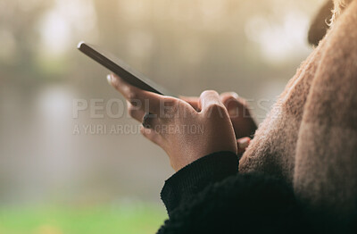 Hands, phone and social media with a person on a blurred background outdoor on an overcast day. Mobile, contact and communication with an adult typing a text message in the rain during winter