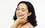 Face, makeup and skincare with a woman in studio isolated on a white background touching her skin. Portrait, beauty and facial with an attractive young female rubbing her cheek for natural treatment