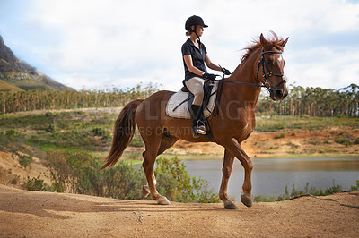 Buy stock photo Equestrian, woman and riding a horse in nature on adventure and journey in countryside. Ranch, animal and rider outdoor with hobby, sport or walking a pet on farm with girl in summer at river