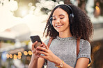 City, headphones and woman with smartphone, typing and connection with happiness, social media and streaming music. Outdoor, female person and girl with a cellphone, contact and headset with audio