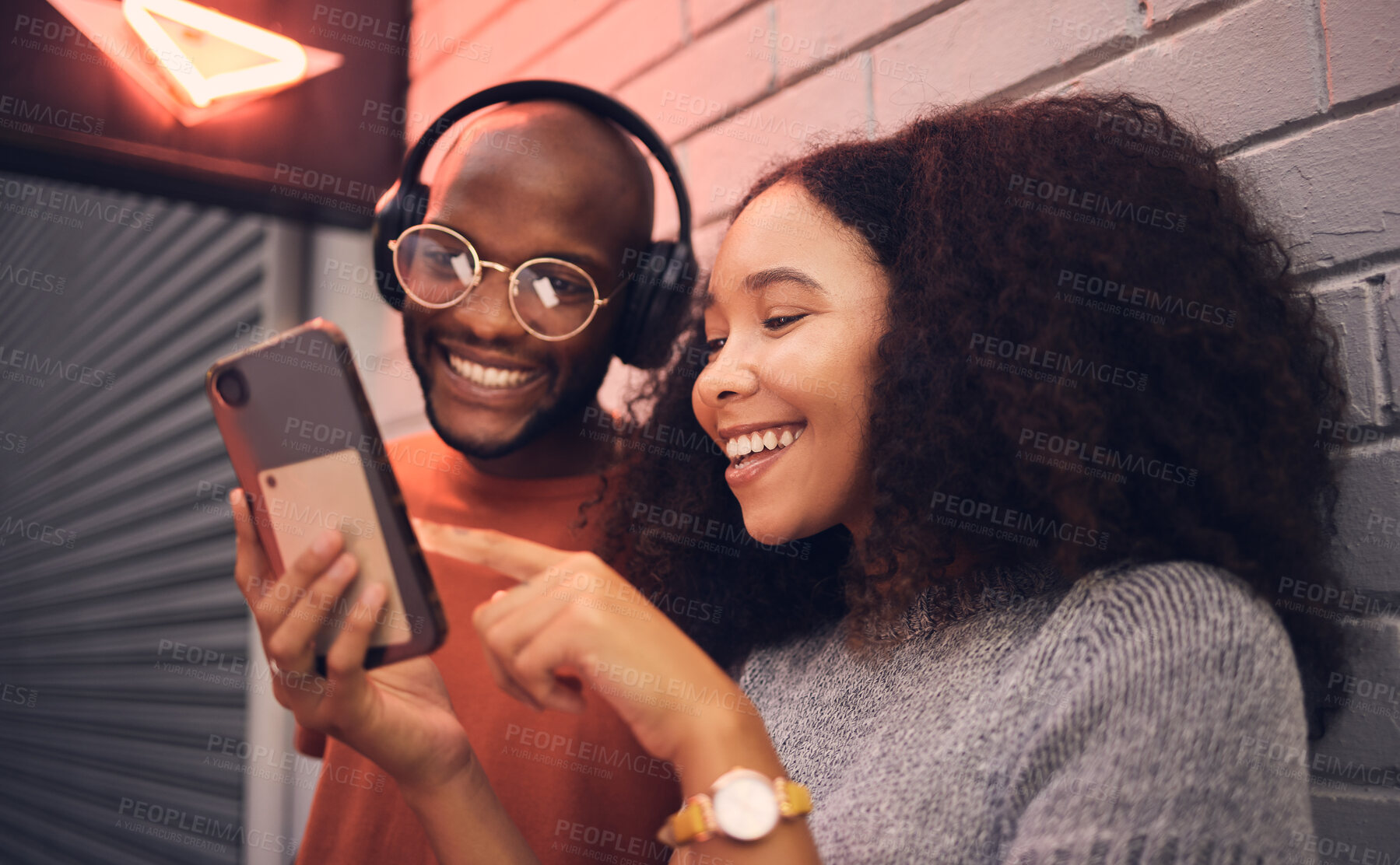 Buy stock photo Phone, music and headphones with a multicultural couple outdoor in a city together for dating. Love, mobile or streaming app with a man and woman bonding in an urban town while listening to the radio
