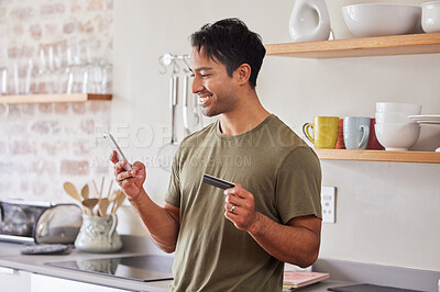 Buy stock photo Credit card, finance and man with smartphone for online shopping in kitchen at home. Indian, make payment with money for e commerce transaction and search the internet for investment.