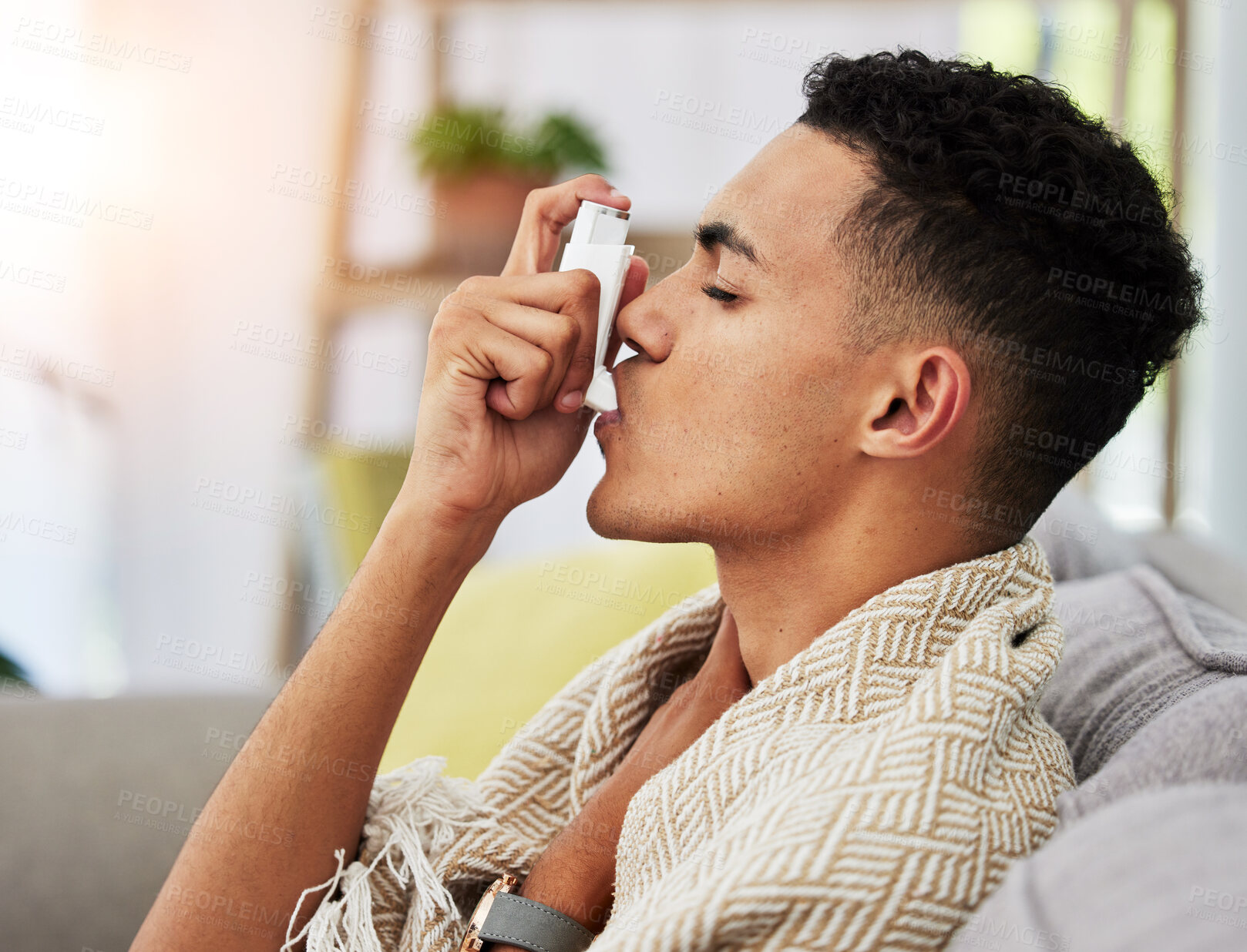 Buy stock photo Asthma, sofa and person with inhaler due to cold, flu and fever in a home living room with a blanket on couch. Healthcare, medical and young with difficult symptoms and sick in a house lounge