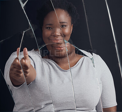 Buy stock photo Healing, success and woman portrait with thumbs up in broken mirror after depression and stress in studio. Face, smile and African female abuse survivor emoji hand for feedback on bipolar treatment