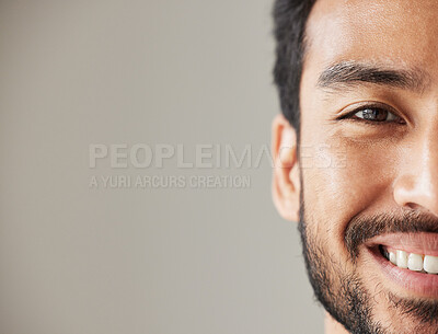 Buy stock photo Half face, portrait and smile of an asian man in studio with positive mindset, wellness and awareness. Young male model isolated on grey background with happiness, mockup space and confident headshot