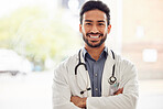 Smile, portrait and asian man doctor with arms crossed in hospital for consulting, exam and help on blurred background. Happy, face and guy healthcare expert proud of service while working at clinic 