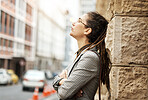 Relax, tired and a business woman in the city, taking a break to rest while on an international trip. Travel, commute and abroad with an exhausted young female employee eyes closed in an urban town