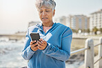 News, phone and fitness with old woman at beach for running, workout and results. Network, communication and contact with female runner training in nature for technology, sports and mobile app