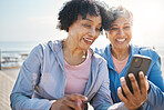 Senior women, phone and social media in nature for a chat, notification or a funny meme. Happy, reading online and elderly friends by the sea with a mobile app for communication or internet memory