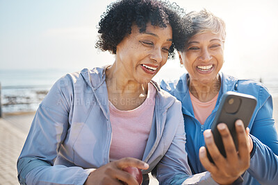 Buy stock photo Senior women, phone and social media in nature for a chat, notification or a funny meme. Happy, reading online and elderly friends by the sea with a mobile app for communication or internet memory