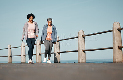 Buy stock photo Fitness, walking and senior women by ocean for healthy lifestyle, wellness and cardio on promenade. Sports, friends and female people in conversation on boardwalk for exercise, training and workout