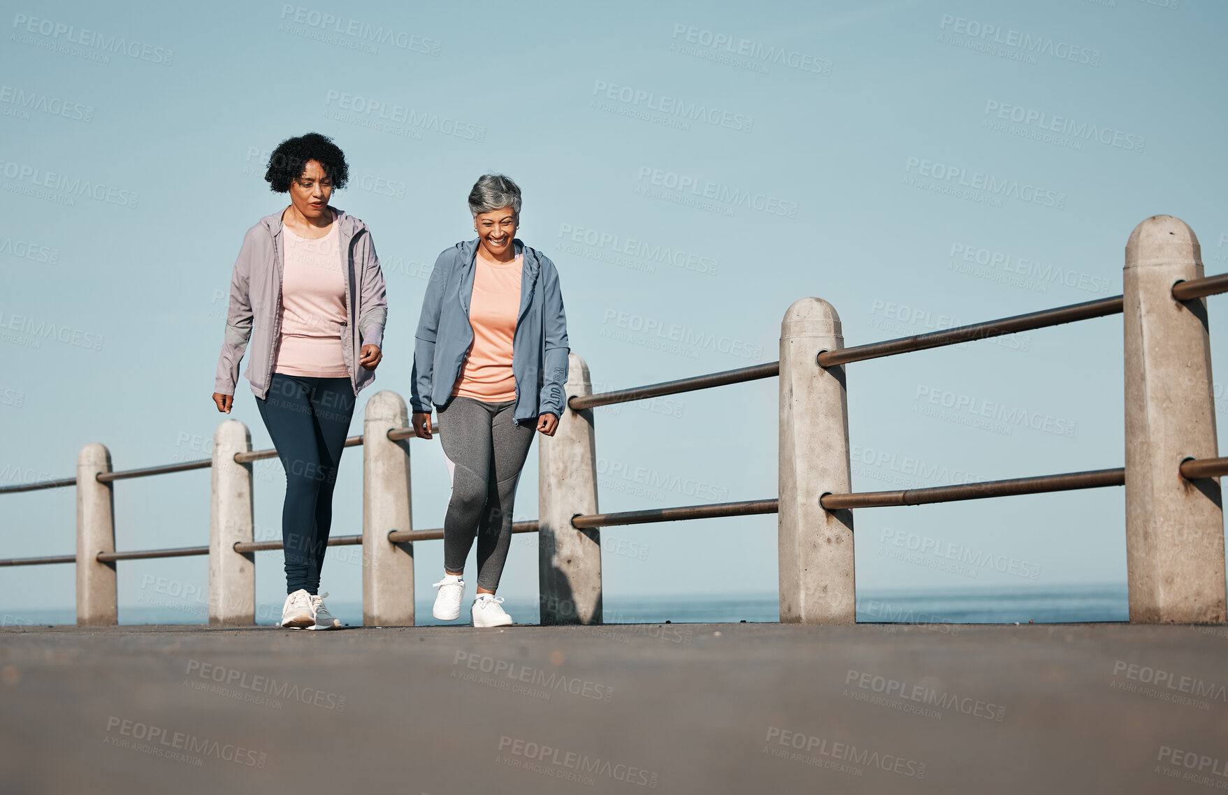 Buy stock photo Fitness, walking and senior women by ocean for healthy lifestyle, wellness and cardio on promenade. Sports, friends and female people in conversation on boardwalk for exercise, training and workout