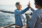 High five, fitness and senior women friends at beach with exercise, celebration and excited in nature. Sport, people and elderly females with hands in support of wellness, training or success at sea