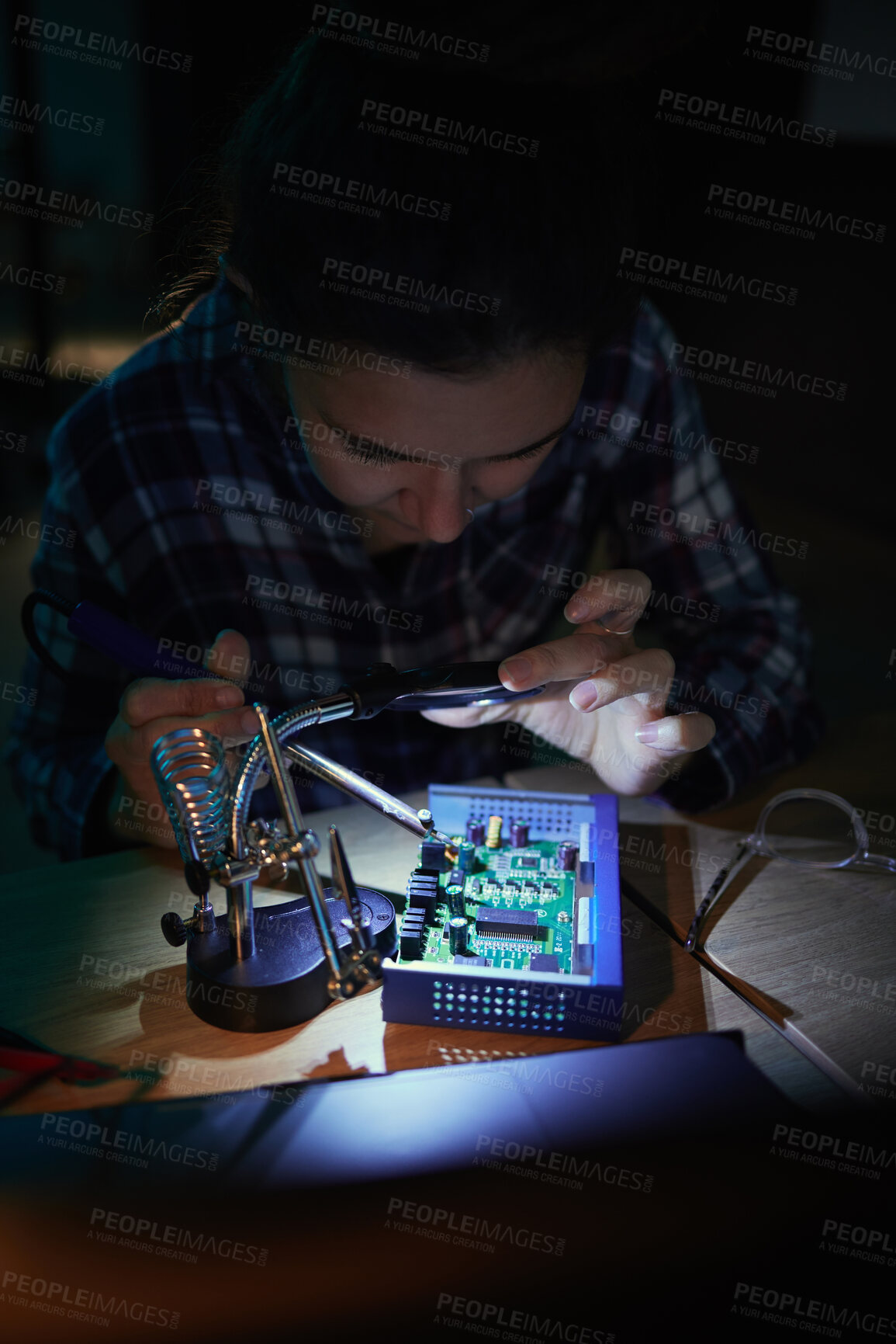 Buy stock photo Woman, computer motherboard and night with soldering iron, manufacturing and microchip for it development. Information technology, circuit board and electronics for engineering, hardware and system