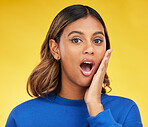 Shock, surprise and portrait of woman in a studio with a puzzled or wtf facial expression. Young, good news and young Indian female model with a wow or omg face isolated by a yellow background.