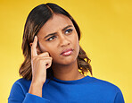 Thinking, confused and young woman in a studio with a dreaming, idea or brainstorming facial expression. Unsure, doubt and Indian female model with a planning or decision face by a yellow background.