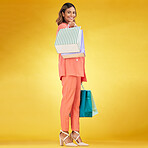 Portrait, happy woman and shopping bag in studio for clothes, retail deal and financial freedom on yellow background. Indian customer, gift bags and discount from fashion store, sales and promotion 